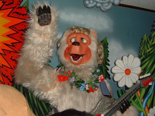 Beach Bear animatronic with his eyes crossed and his arm waving above him.