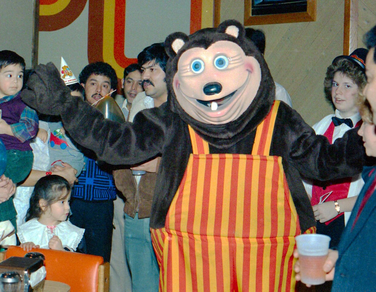 A person at a Showbiz Pizza party in a Billy Bob walkaround suit.